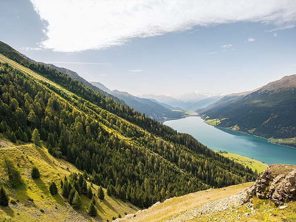 Landschaftsaufnahme vom Reschensee und umliegenden Bergen