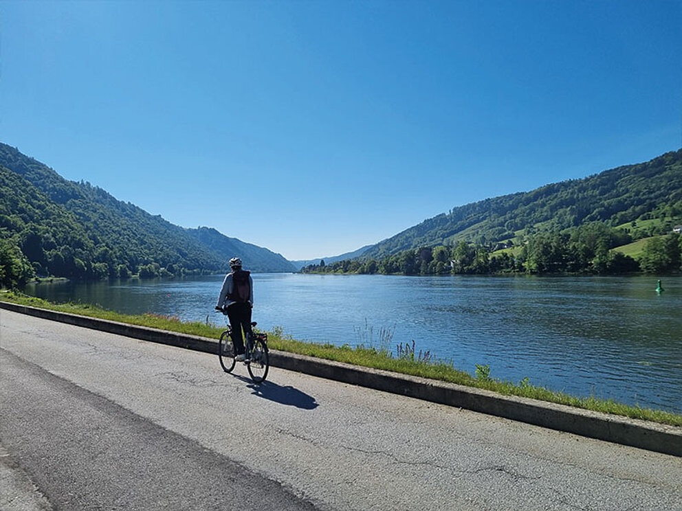 Eine Dame am Fahrrad am Donauufer