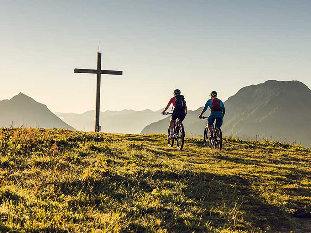 2 Mountainbiker ganz nah am Gipfelkreuz