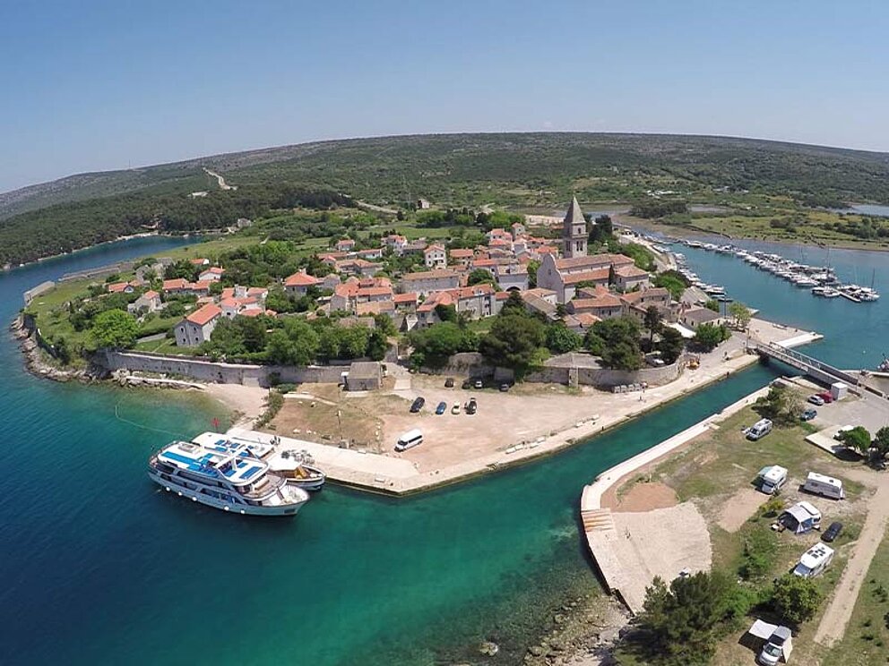 Das Inselhüpfen-Schiff vor einer kleinen Insel