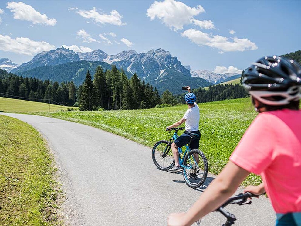 2 Mountainbiker von hinten, im Hintergrund Berge
