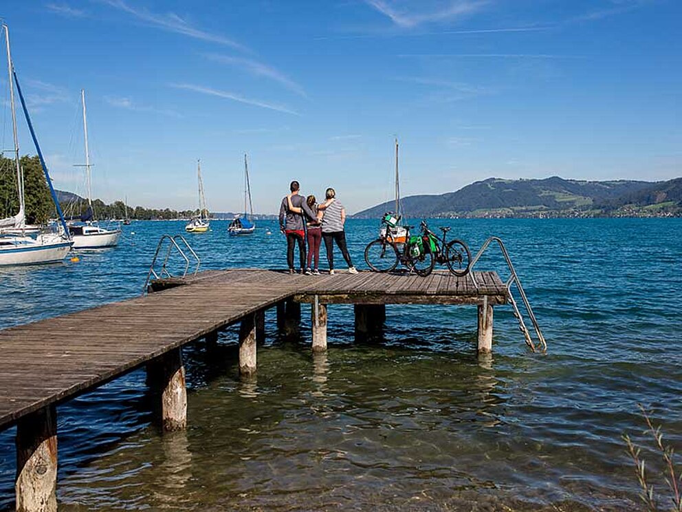 Familie am Steg genießt Ausblick auf den Attersee