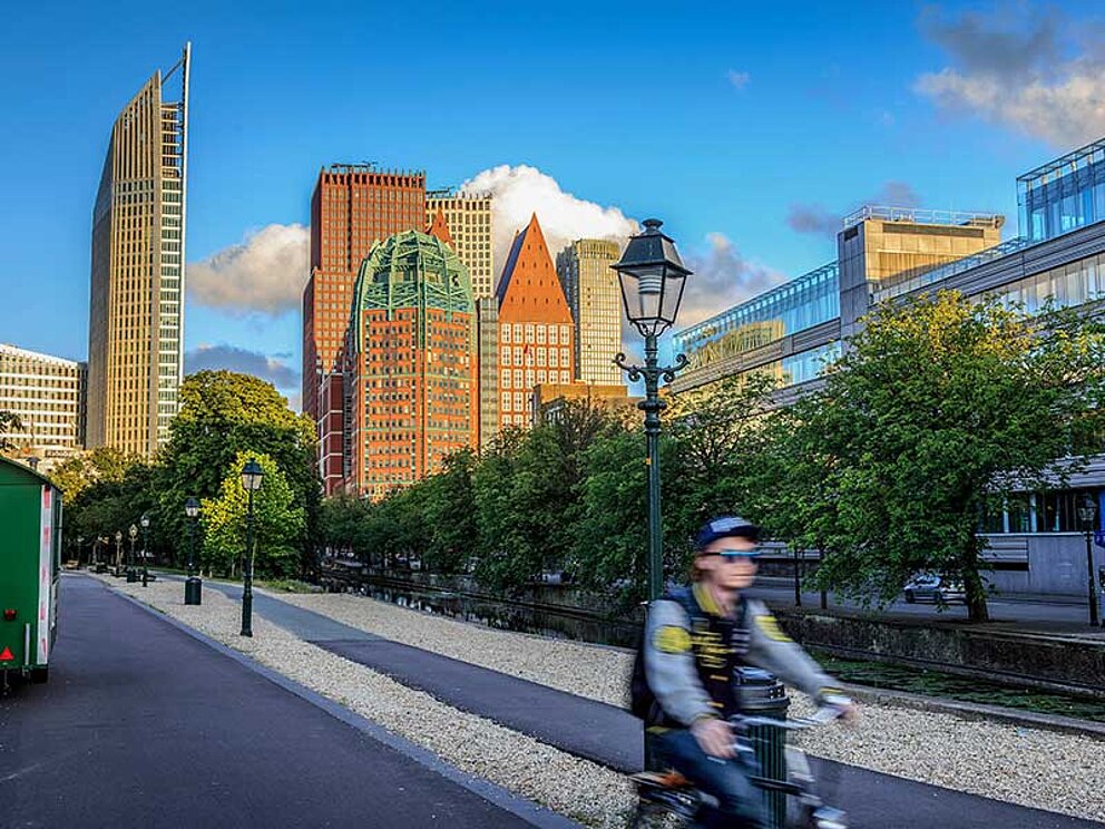 ein Radfahrer vor der Skyline von Den Haag