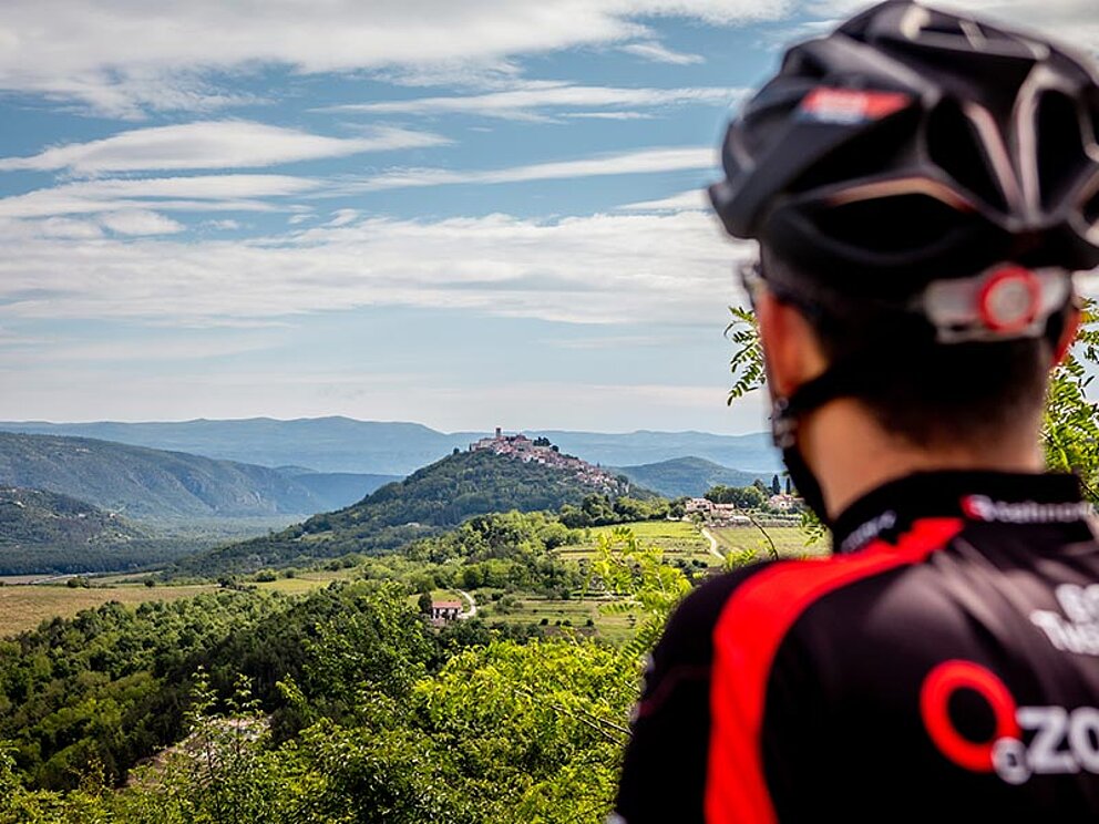 ein Radfahrer von hinten, im Hintergrund Weitblick in die Landschaft