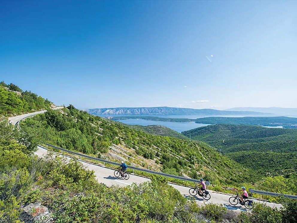 Radfahrer auf einer Straße im hügeligen Gelände von Hvar.
