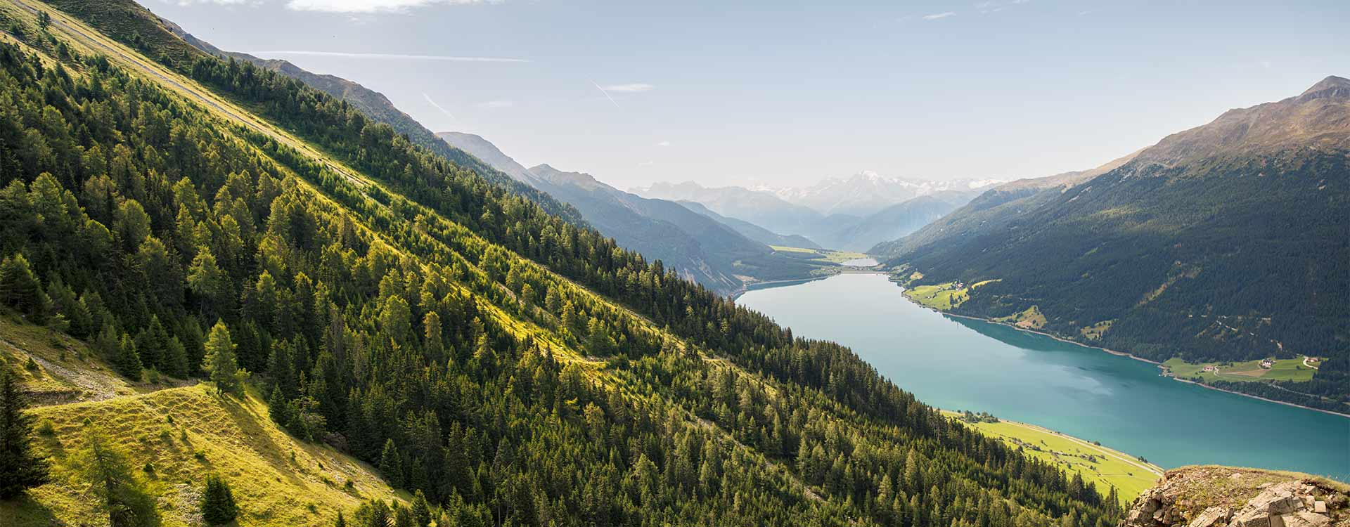 Landschaftsaufnahme vom Reschensee mit umliegenden Bergen