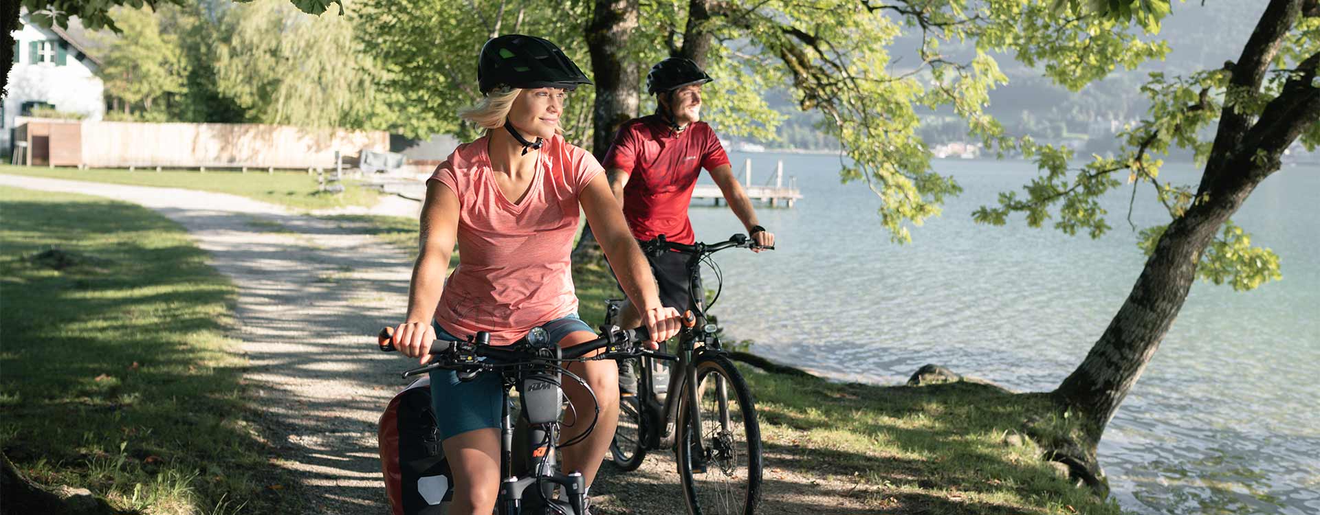 2 Radfahrer am schattigen Radweg am Seeufer