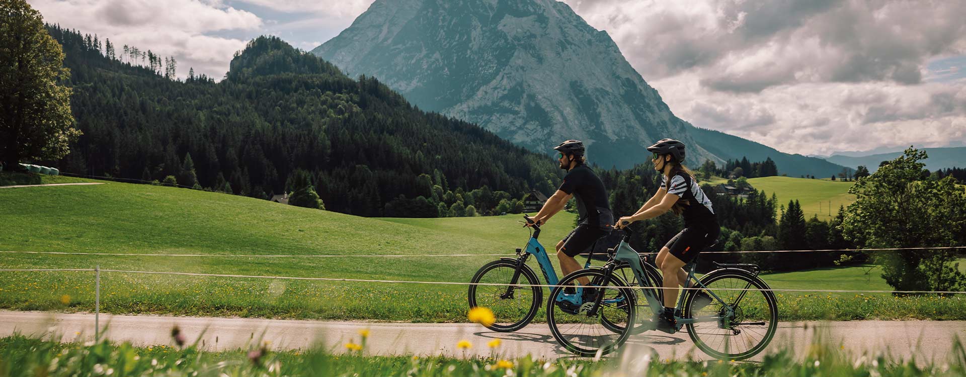 2 Radfahrer auf KTM Elektrorädern vor Bergkulisse