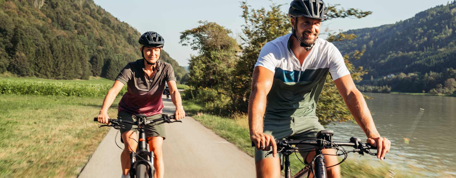 2 Radfahrer fahren entlang der Donau