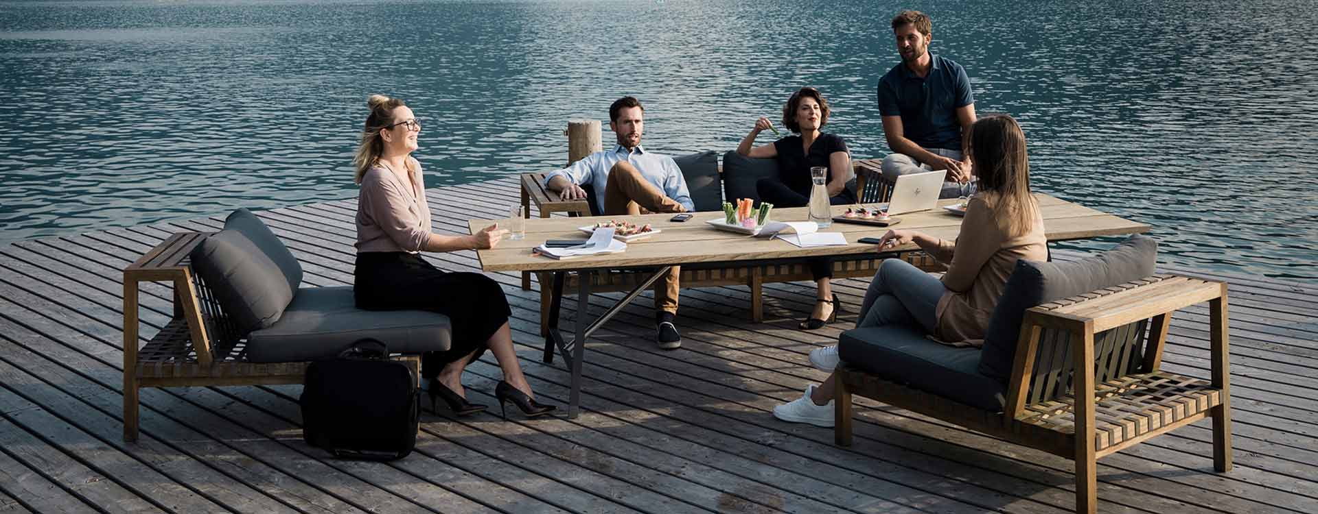 Afterwork gettogether auf gemütlichen Lounge Möbeln auf einer Plattform am Wolfgangsee